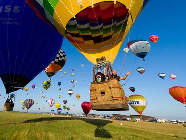 Ratusan balon udara terbang di pangkalan udara Chambley-Bussieres, Hagéville, Prancis, Senin (29/7/2019). Acara ini bagian dari pertemuan Grand-Est Mondial Air Ballons (GEMAB). (Jean-Christophe VERHAEGEN/AFP)