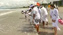 Umat Hindu Bali mengamnil air bersiap melakukan upacara Melasti di pantai Petitenget, Bali, Rabu (14/3). Melasti ini merupakan bagian dari empat tahapan yang dilaksanakan pra-Nyepi, atau sebelum Nyepi. (AFP Photo/Sonny Tumbelaka)