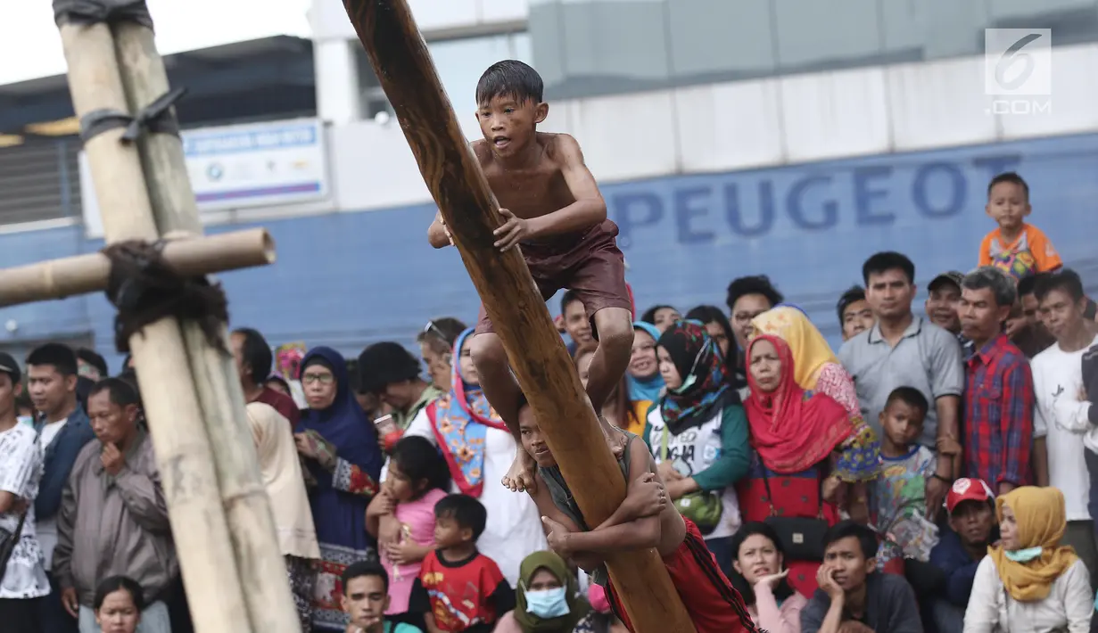 Ekspresi seorang anak saat mengikuti panjat pinang dalam Festival Kalimalang di Cipinang Melayu, Jakarta Timur, Kamis (17/8). Festival Kalimalang ini dalam rangka memeriahkan HUT ke-72 RI. (Liputan6.com/Herman Zakharia)