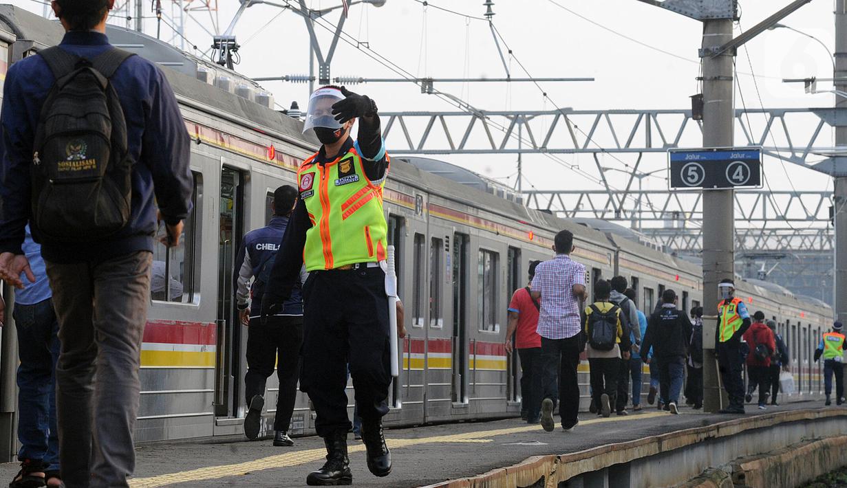 Petugas stasiun memandu penumpang KRL Commuterline di Stasiun Bogor, Jawa Barat, Selasa (9/6/2020) pagi. Puluhan polisi, TNI, Satpol PP, dan petugas stasiun diterjunkan untuk memandu penumpang mengantisipasi antrean panjang seperti kemarin. (merdeka.com/Arie Basuki)