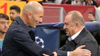 Pelatih Real Madrid Zinedine Zidane (kiri) berbicara dengan Manajer Galatasaray Fatih Terim jelang bertanding pada laga Liga Champions di Istanbul, Turki, Selasa (22/10/2019). Real Madrid mengalahkan Galatasaray lewat gol tunggal Toni Kroos. (AP Photo)