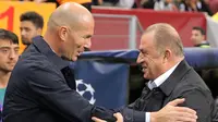 Pelatih Real Madrid Zinedine Zidane (kiri) berbicara dengan Manajer Galatasaray Fatih Terim jelang bertanding pada laga Liga Champions di Istanbul, Turki, Selasa (22/10/2019). Real Madrid mengalahkan Galatasaray lewat gol tunggal Toni Kroos. (AP Photo)