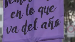 Rombongan teater Vichama melakukan prosesi kamar mayat berjudul "Kami Ingin Diri Sendiri Hidup!" sambil membawa tubuh tiruan dan menampilkan tanda-tanda kiasan pada malam Hari Anti Kekerasan Terhadap Perempuan di Villa El Salvador, Lima, Peru, 24 November 2021. (Cris BOURONCLE/AFP)