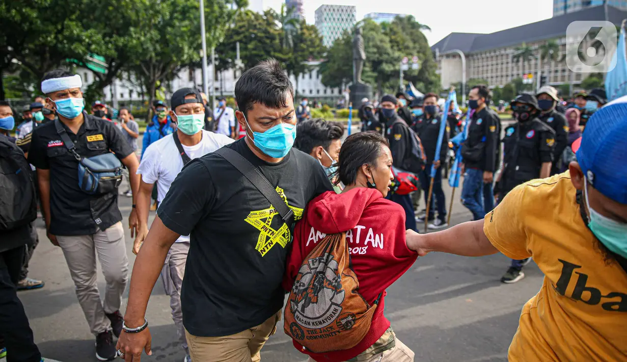 Petugas kepolisian mengamankan massa yang diduga hendak berbuat kericuhan saat aksi unjuk rasa di kawasan Patung Kuda, Jakarta, Kamis (22/10/2020). Penangkapan dilakuka  untuk mencegah hal hal yang tak di inginkan saat unjuk rasa. (Liputan6.com/Faizal Fanani)