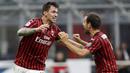 Pemain AC Milan, Alessio Romagnoli dan Giacomo Bonaventura, merayakan gol ke gawang Parma pada laga Serie A di Stadion San Siro, Rabu (15/7/2020). AC Milan menang 3-1 atas Parma. (AP Photo/Luca Bruno)