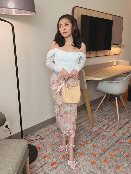 Tampil feminin dan anggun, Prilly memadukan off the shoulder top dengan rok pencil motif bunga. [Foto: IG/prillylatuconsina96].
