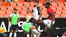 Penyerang AC Milan, Rafael Leao mengontrol bola dari kawalan bek Valencia, Omar Alderete selama pertandingan persahabatan di Stadion Mestalla di Valencia (4/8/2021). Bermain imbang 0-0 di waktu normal, AC Milan kalah atas Valencia lewat adu penalti 5-3. (AFP/Jose Jordan)