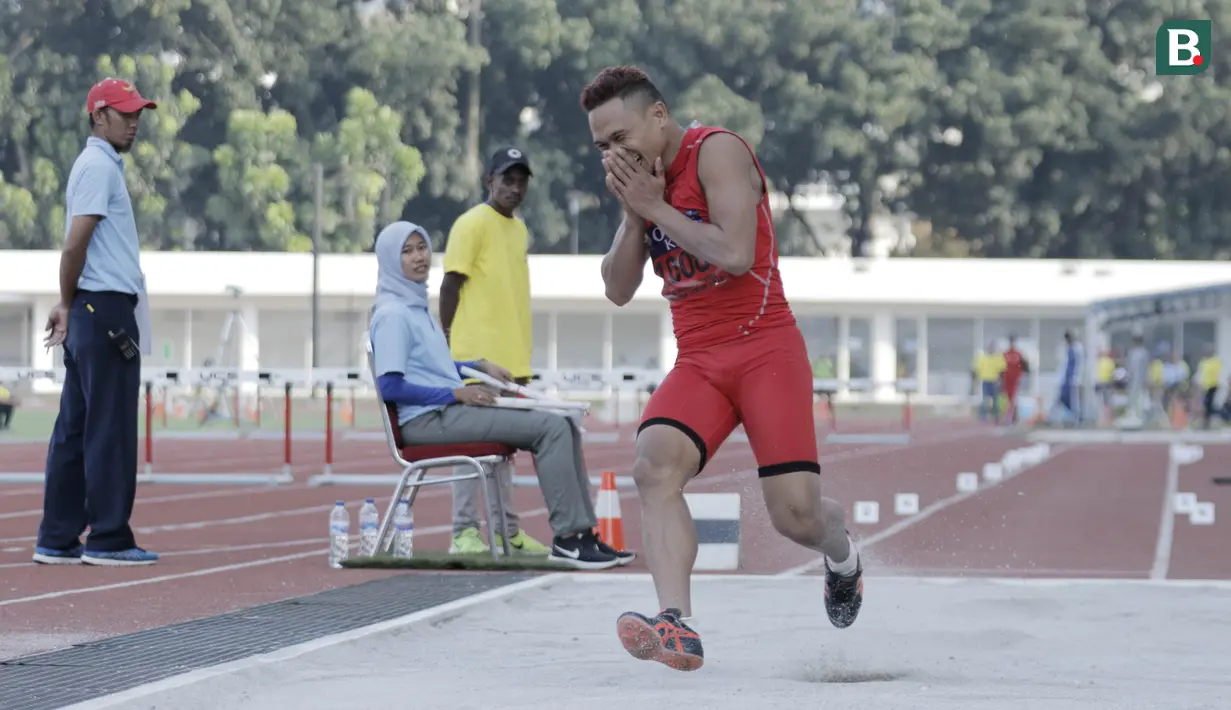 Atlet lompat jauh DKI Jakarta, Noval, tertawa usai melakukan lompatan saat kejurnas atletik di Stadion Madya, Senayan, Jakarta, Rabu (9/5/2018). Noval berhasil menjadi juara dengan loncatan sejauh 7,14 Meter. (Bola.com/M Iqbal Ichsan)