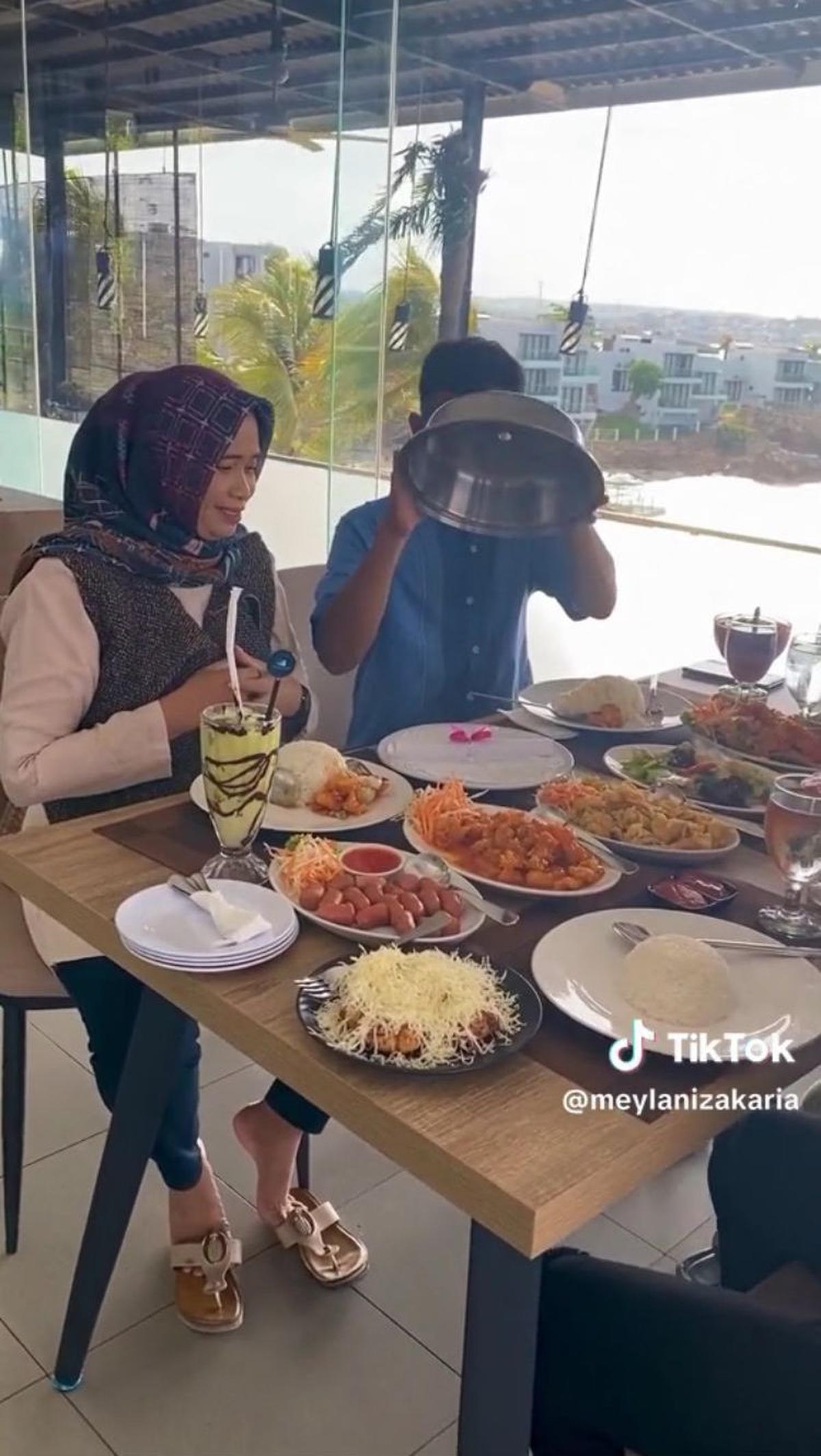 Ayahnya pun membuka penutup piring yang cukup besar tersebut dan menjumpai sebuah kertas dengan pita berwarna pink.