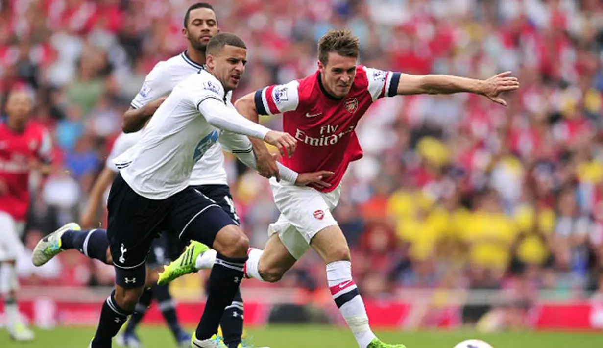 Gelandang Arsenal Welsh Aaron Ramsey (kanan) duel dengan bek Tottenham Hotspur Kyle Walker (kiri) pada pertandingan sepak bola Liga Utama Inggris antara Arsenal dan Tottenham Hotspur di Stadion Emirates, London (01/09/2013). (AFP/Glyn Kirk)