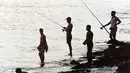 Sekelompok nelayan saat memancing pada pagi hari di sepanjang garis pantai dekat Havana pada 3 Agustus 1991 dengan rute maraton Pan American Games. (AFP/Don Emmert)