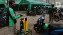 Pengemudi ojek online melakukan penyemprotan disinfektan sebelum mengangkut penumpang di Shelter Sudirman, Jakarta, Senin (8/6/2020). Pemprov DKI mulai mengizinkan ojek daring maupun konvensional mengangkut penumpang di PSBB transisi dengan menerapkan protokol kesehatan. (Liputan6.com/Angga Yuniar)