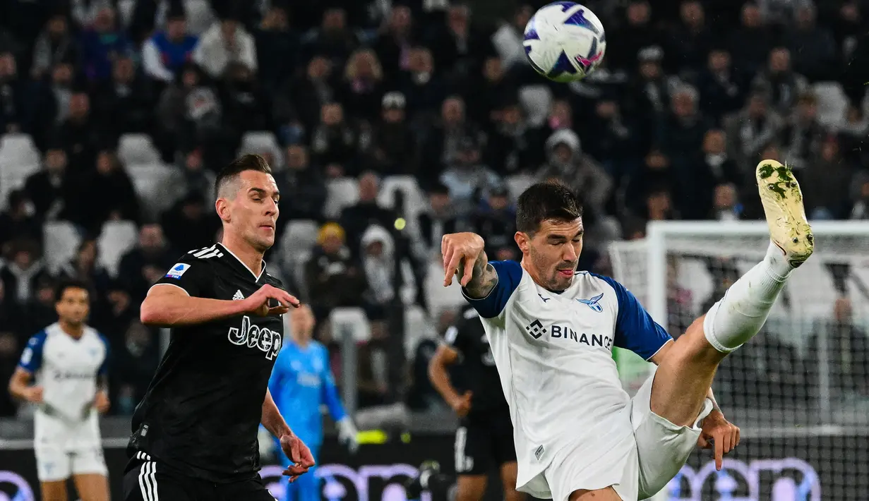 Bek Lazio Alessio Romagnoli menguasai bola di bawah tekanan dari penyerang Juventus Arkadiusz Milik pada pekan ke-15 Serie A 2022/2023 di Allianz Stadium, Senin (14/11/2022) dini hari WIB. Moise Kean jadi bintang dalam laga ini. (Vincenzo PINTO / AFP)