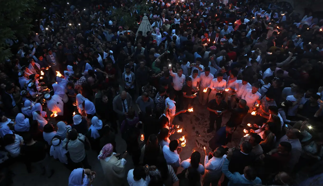 Kelompok Yazidi Irak membawa obor parafin berkumpul di luar kuil Lalish saat perayaan Tahun Baru Yazidi di lembah dekat Dohuk, Irak (17/4). (AFP/Safin Hamed)