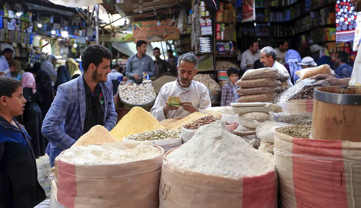 Warga berbelanja menjelang bulan suci Ramadan di pasar kota tua Sanaa, Yaman, Sabtu (18/4/2020). Di tengah pandemi virus corona COVID-19, umat muslim di Yaman dilarang untuk menggelar buka puasa bersama hingga salat berjemaah di masjid. (Mohammed HUWAIS/AFP)