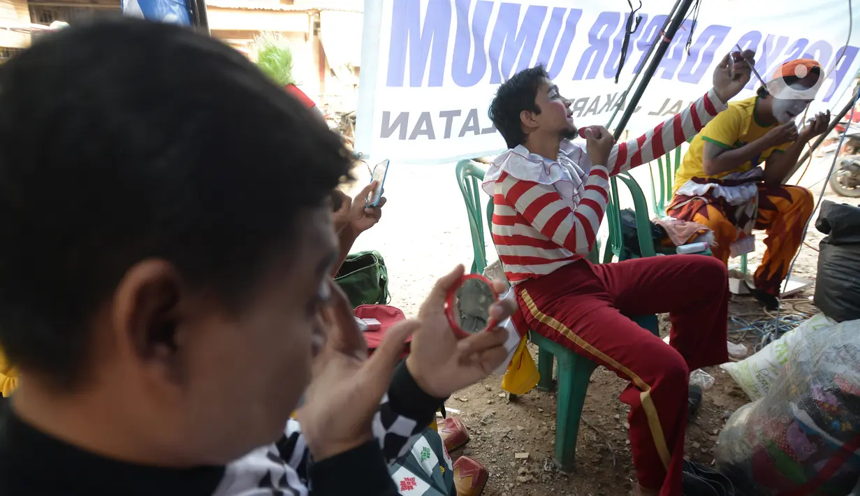Badut komunitas Aku Badut Indonesia bersiap menghibur anak-anak di pengungsian korban kebakaran di Jalan Kemang Utara IX, Jakarta Selatan, Rabu (18/8/2021). Dengan memberi hiburan, diharap anak-anak dapat melupakan kesedihan dan keresahan yang mereka alami pascakebakaran. (merdeka.com/Imam Buhori)