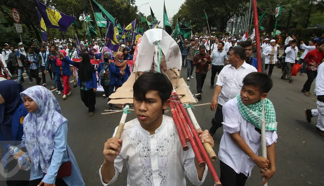 Massa aksi membawa keranda saat melintas di Jalan Medan Merdeka Selatan, Jakarta, Jumat (4/11). Dalam aksinya, massa menuntut agar polisi segera menangkap Gubernur Nonaktif Basuki T Purnama atas dugaan penistaan agama. (Liputan6.com/Immanuel Antonius)
