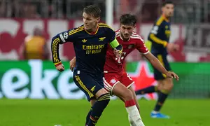 Pemain Arsenal, Martin Odegaard (kiri), dan pemain Bayern Munchen, Tom Bischof, berebut bola dalam pertandingan Liga Champions, Jerman, Kamis (22/10/2026). (AP Photo/Martin Meissner)