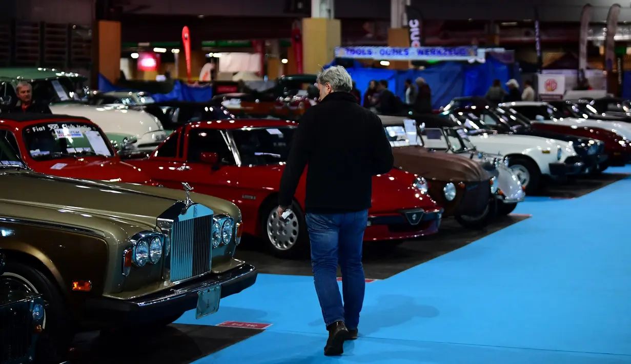Seorang lelaki memandangi sebuah mobil tua yang ditampilkan selama pameran mobil klasik Retromobile di Porte de Versailles, di Paris (4/2/2020). Retromobile berlangsung dari 5 Februari hingga 9 Februari 2020. (AFP Photo/Martin Bureau)