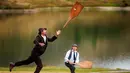 Orang-orang memainkan permainan tradisional 'Gilihuesine' di resor pegunungan Bettmeralp, Swiss (16/9). Permainan ini dimainkan dengan cara memukul tulang kaki sapi dengan tongkat. (Valentin Flauraud/Keystone via AP)