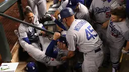 Pemain Los Angeles Dodgers, Cody Bellinger dibantu rekan-rekannya saat terjatuh di tempat istirahat pada pertandingan kelima dalam game 3 dari Divisi Liga Nasional baseball di Phoenix (9/10). (Christian Petersen / Getty Images / AFP)