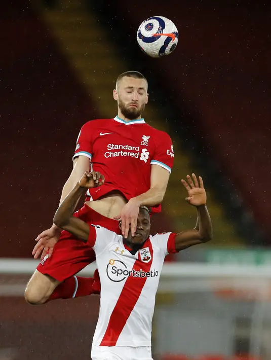 Bek Liverpool, Nathaniel Phillips berebut bola dengan pemain Southampton, Moussa Djenepo pada pertandingan lanjutan Liga Inggris di stadion Anfield di Liverpool, Inggris, Minggu (9/5/2021). Berkat hasil ini, Liverpool menghuni posisi keenm dengan koleksi 57 poin. (Phil Noble / Pool via AP)