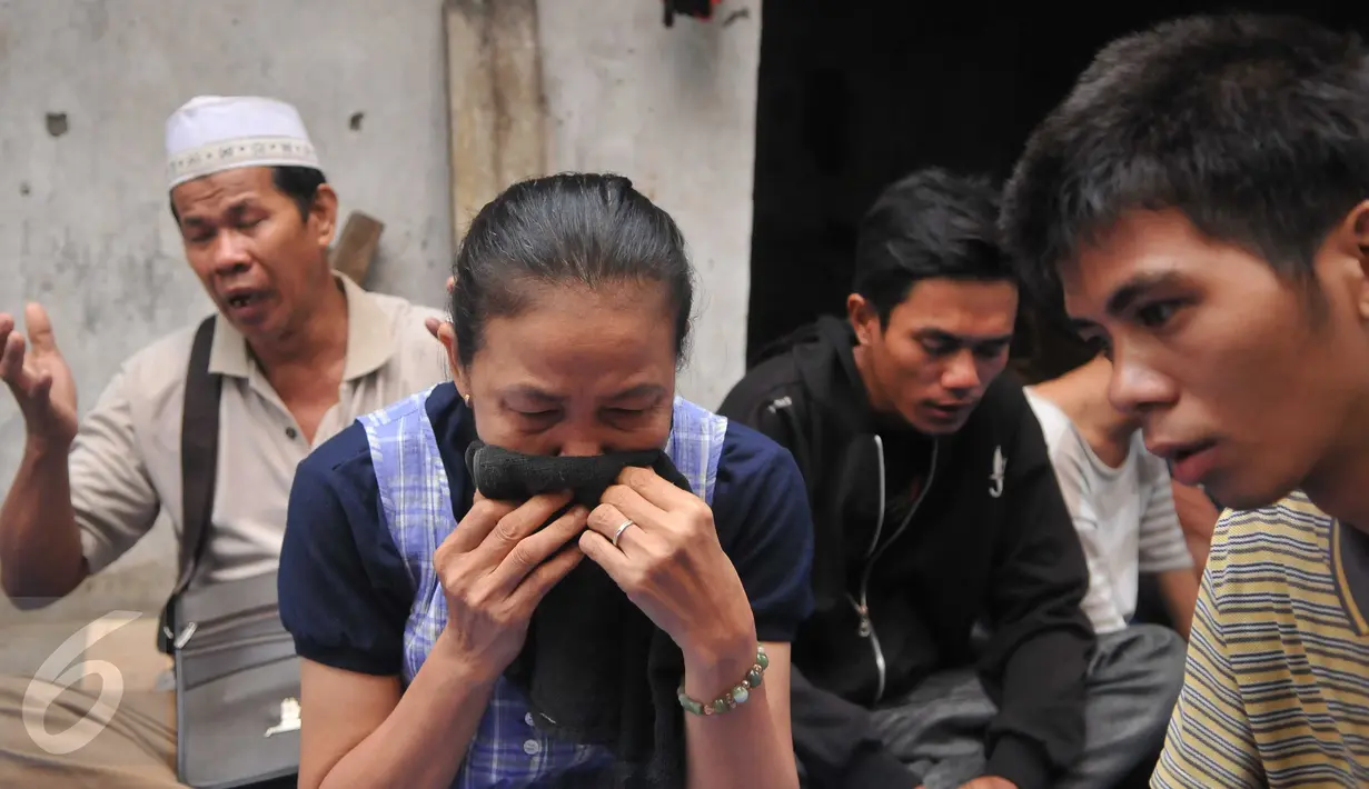 Seorang ibu tampak bersedih saat mengikuti doa bersama jelang penertiban permukiman Kampung Akuarium, Penjaringan, Jakarta, Senin (11/4). Mereka berdoa dengan khusuk di antara gang sempit, dengan menggelar terpal. (Liputan6.com/Gempur M Surya)