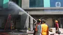Petugas menyemprotkan air saat berusaha memadamkan kebakaran di Gedung Cyber 1, Jakarta, Kamis (2/12/2021). Sampai saat ini, penyebab kebakaran masih belum diketahui. (Liputan6.com/Herman Zakharia)