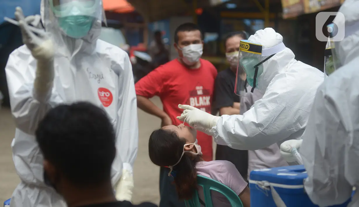 Petugas medis melakukan swab tes Covid-19 pemilik kios di pasar Perumnas Klender, Jakarta, Jumat (29/5/2020). Sebanyak, 50 pedagang pasar menjalani Rapid Test dan Swab Test untuk kedua kalinya yang mana sudah dilakukan sebelumnya ada hasil reaktif lima orang pedagang pasar. (merdeka.com/Imam Buhori)