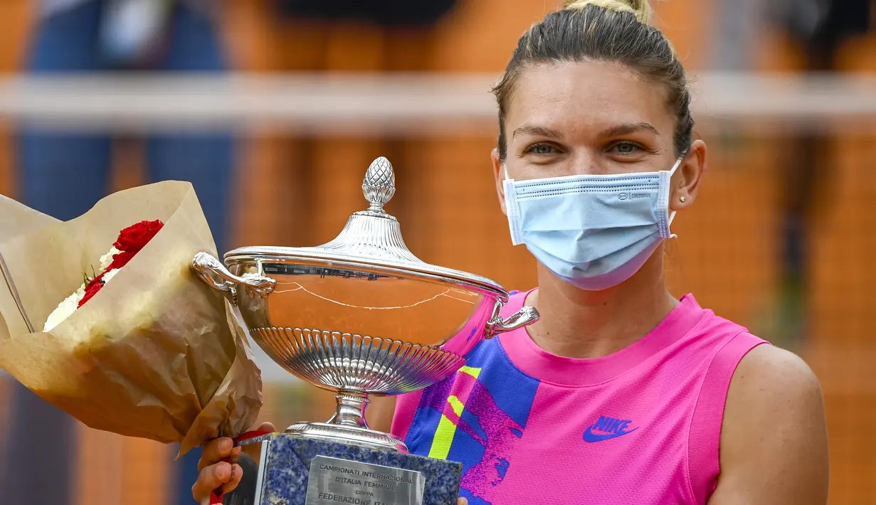 Petenis Romania, Simona Halep, memeluk trofinya saat meraih gelar juara Italia Terbuka 2020 di Foro Italico, Roma Italia, Senin (21/9/2020). Simona Halep menjuarai Italia Open 2020 setelah Karolina Pliskova mundur karena cedera pada menit ke-32. (AFP/Riccardo Antimiani/pool)