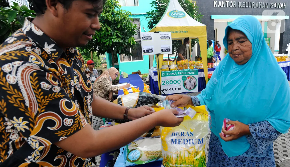 Petugas melayani warga yang membeli bahan kebutuhan pokok dengah harga di bawah harga eceran tertinggi (HET) saat kegiatan operasi pasar di Kantor Kelurahan Sawah, Tangerang Selatan, Banten, Kamis (29/9/2022). Dinas Perindustrian dan Perdagangan (Disperindag) Kota Tangerang Selatan menggelar operasi pasar di tujuh kecamatan dalam rangka penanganan inflasi sebagai dampak kenaikan harga bahan bakar minyak (BBM). (merdeka.com/Arie Basuki)