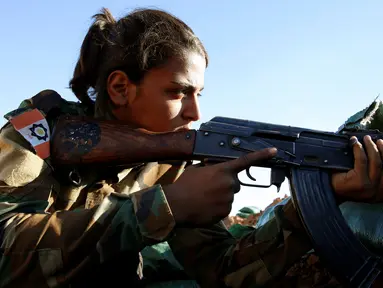 Seorang pejuang wanita Iran-Kurdi membidikan senjatanya saat ikut pertempuran melawan kelompok radikal Negara Islam (ISIS) di Bashiqa, dekat Mosul, Irak, Kamis (3/11). (Reuters/Ahmed Jadallah)