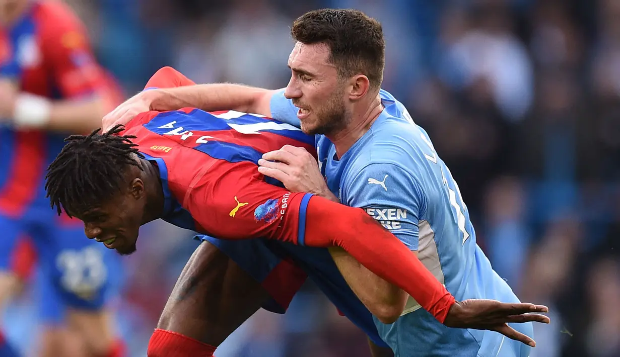 Alih-alih bangkit, Manchester City malah harus bermain dengan 10 pemain setelah Aymeric Laporte (kanan) diganjar kartu merah. Apesnya lagi, The Citizen harus kebobolan di babak kedua lewat gol  Wilfried Zaha (kiri). (AFP/Oli Scarff)