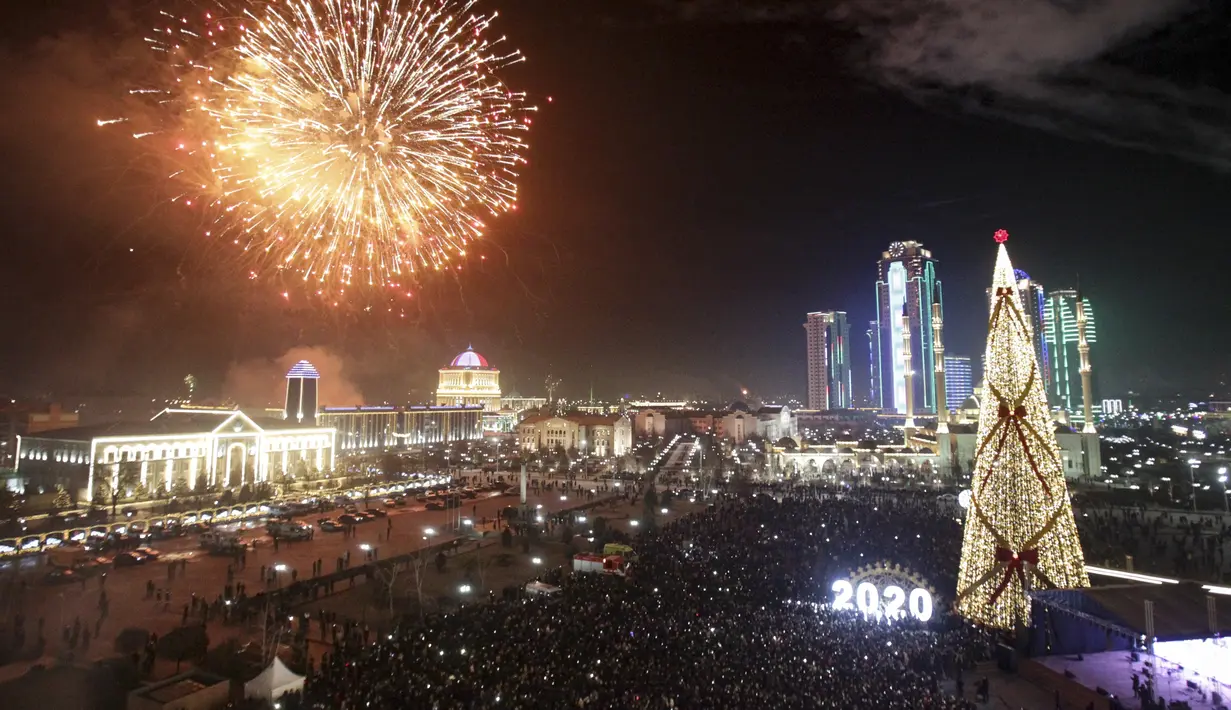 Kembang api meledak di atas pohon Natal dan gedung pencakar langit selama perayaan Tahun Baru di Grozny, Rusia, Rabu (1/1/2020). (AP Photo/Musa Sadulayev)