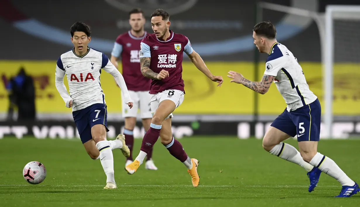 Pemain Burnley, Josh Brownhill mengumpan bola dari kawalan dua pemain Tottenham Hotspur Son Heung-min dan Pierre-Emile Hojbjerg pada pertandingan lanjutan Liga Inggris di stadion Turf Moor, Burnley, Inggris, Senin (26/10/2020). Tottenham menang tipis 1-0 atas Burnley. (Michael Regan/Pool via AP)