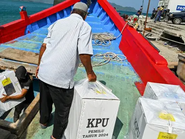 Para pekerja memuat logistik pemilu 2024 ke dalam perahu menuju pulau-pulau terpencil, di Pulo Aceh, Banda Aceh pada 12 Februari 2024. (CHAIDEER MAHYUDDIN/AFP)