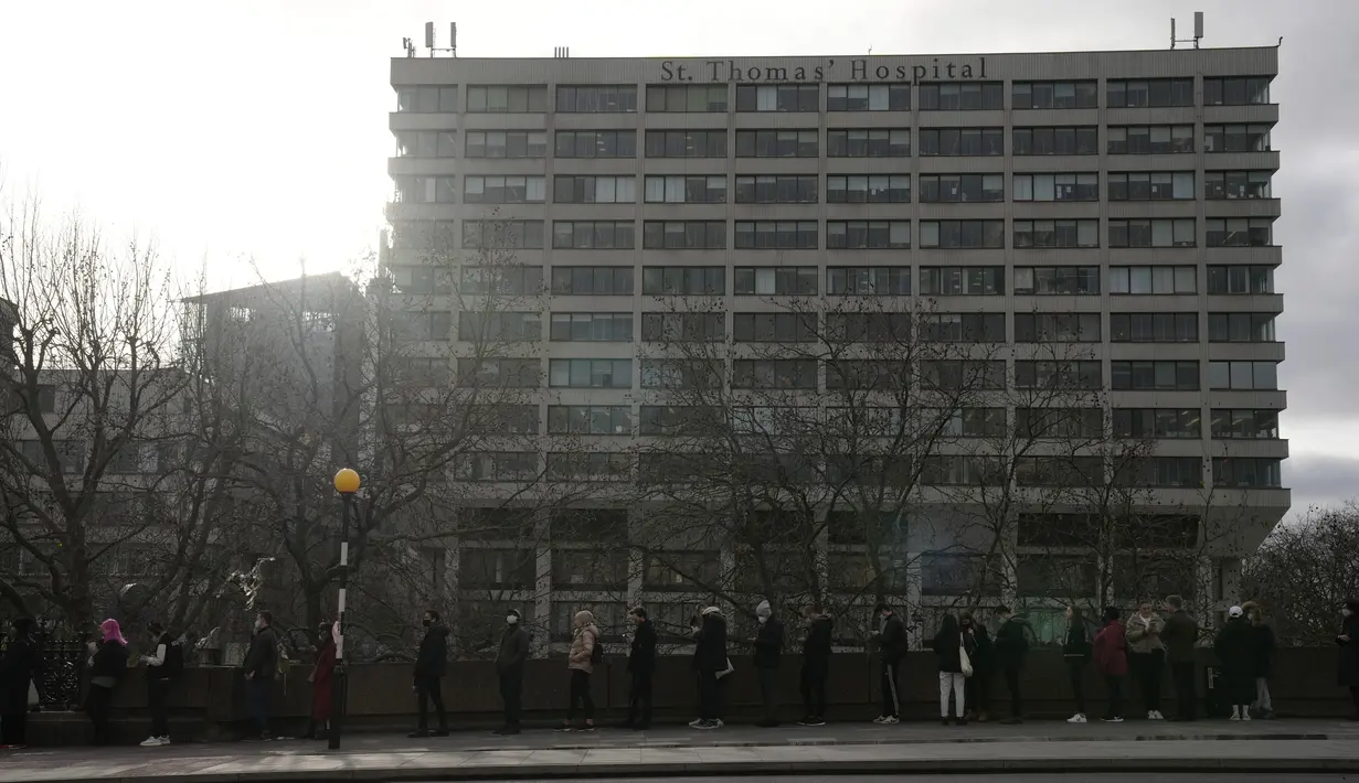 Orang-orang antre untuk suntikan vaksin booster Covid-19 di Rumah Sakit St Thomas, London, Senin (13/12/2021). Antrean panjang terbentuk di pusat vaksinasi di Inggris ketika pemerintah mendorong agar semua orang dewasa mendapatkan vaksin booster untuk cegah penyebaran Omicron. (AP Photo/Matt Dunham)