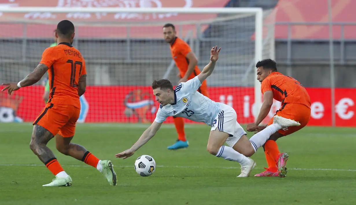 Pemain Skotlandia James Forrest (tengah) terjatuh saat melawan Belanda pada pertandingan persahabatan di Stadion Algarve, luar Faro, Portugal, Rabu (2/6/2021). Pertandingan berakhir imbang 2-2. (AP Photo/Miguel Morenatti)