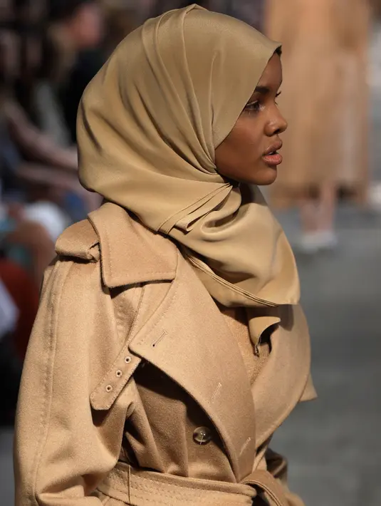 Model berhijab keturunan Amerika-Somalia, Halima Aden berjalan di runway Milan Fashion Week membawakan koleksi Max Mara women's Fall/Winter 2017-2018 di Milan, Kamis (23/2). Halima Aden disejajarkan dengan model ternama, Gigi Hadid. (AP Photo/Luca Bruno)