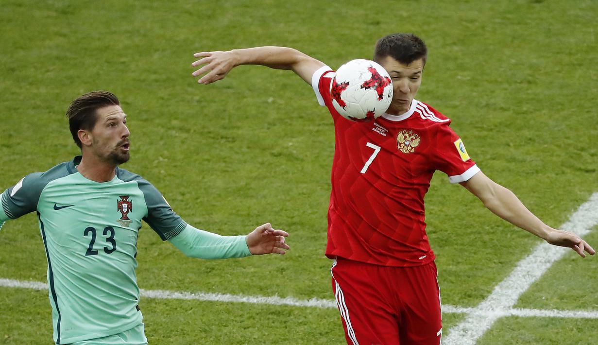 Aksi pemain Rusia, Dmitry Poloz (kanan) mengahalau bola dari kejaran pemain Portugal, Adrien Silva pada laga grup A Piala Konfederasi 2017 di Spartak Stadium, Moscow, (21/6/2017). Portugal menang 1-0. (AP/Alexander Zemlianichenko)