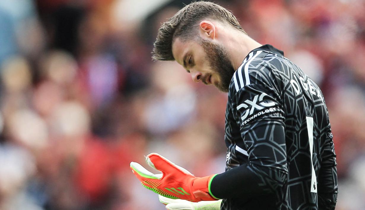 Kiper Manchester United, David de Gea, mengamati kedua tangannya saat melawan Brighton and Hove Albion pada laga Liga Inggris di Stadion Old Trafford, Minggu (07/08/2022). (AP/Lindsey Parnaby)