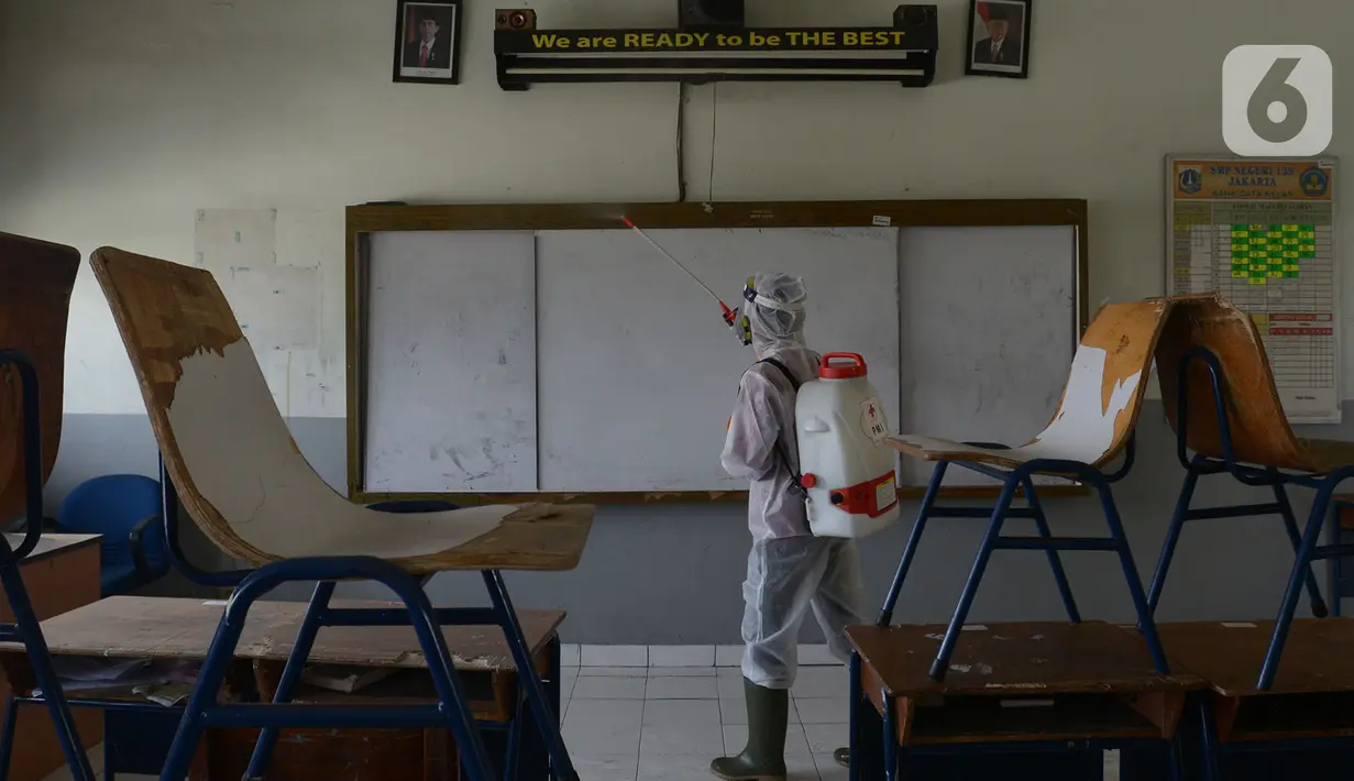 Petugas PMI menyemprotkan cairan disinfektan di Lingkungan SMP Negeri 139 Jakarta, Selasa (9/6/2020). Penyemprotan untuk mencegah penyebaran virus Corona di lingkungan sekolah itu sebagai persiapan memasuki tahun ajaran baru 2020/2021. (merdeka.com/Imam Buhori)