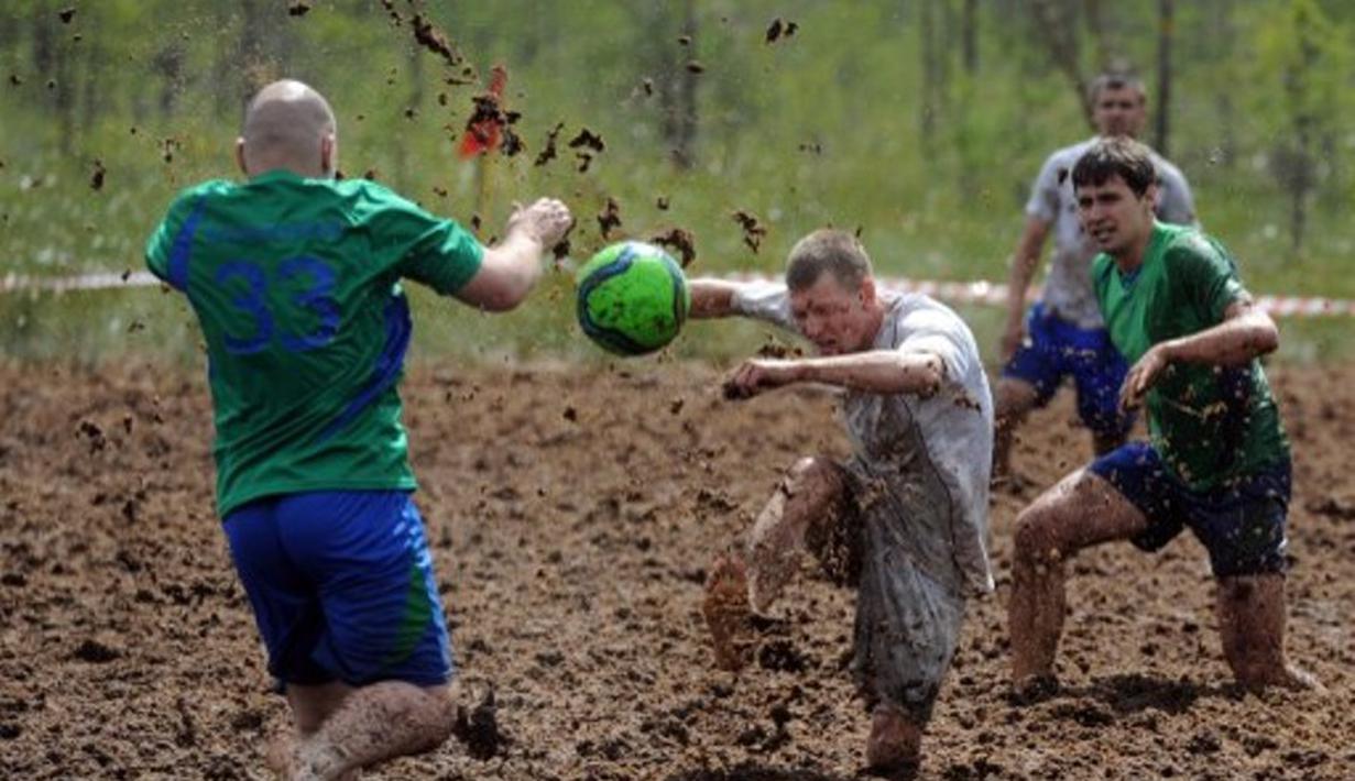Pemain sepak bola rawa berebut bola dalam turnamen memperebutkan Piala Rusia yang berlangsung di Saint Petersburg, Rusia. Sabtu (27/6). (AFP PHOTO/OLGA MALTSEVA)
