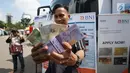 Warga menunjukkan uang pecahan yang ditukarkan dari mobil kas keliling di Lapangan IRTI Monas, Rabu (7/6). Bank Indonesia dan 13 bank umum membuka gerai penukaran uang pecahan dengan penukaran maksimal Rp3,7 juta per orang. (Liputan6.com/Angga Yuniar)