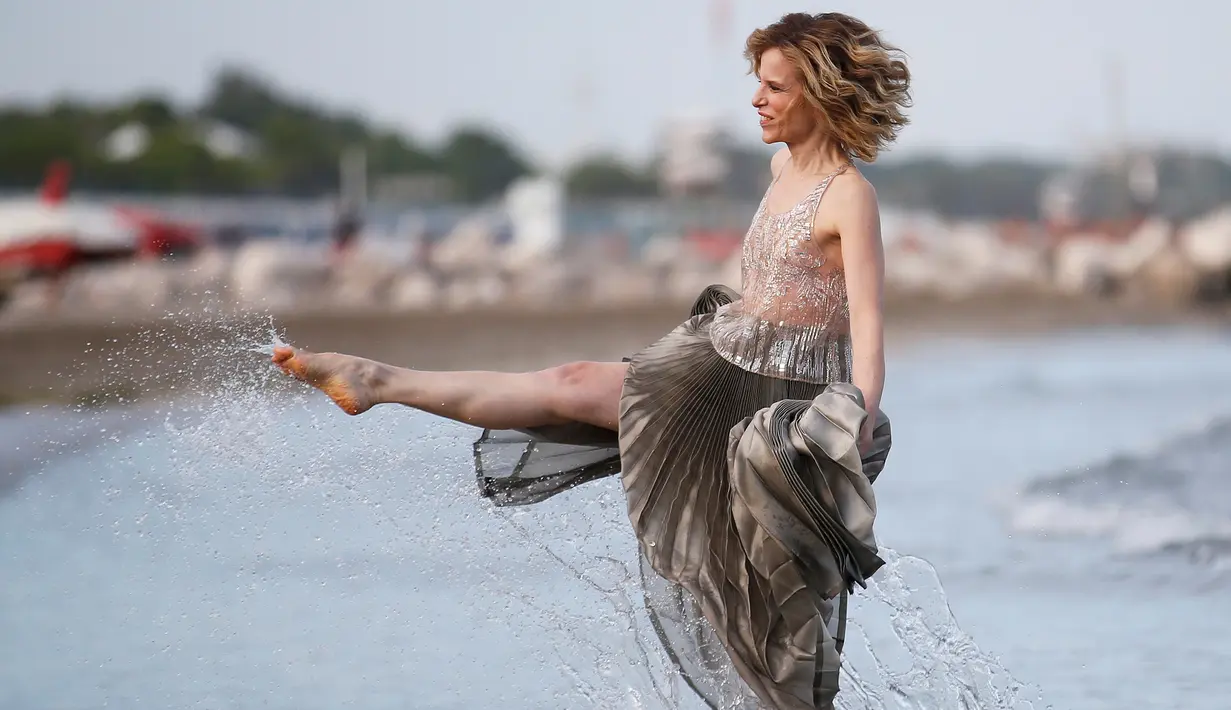 Sonia Bergamasco menggunakan kakinya saat bermain air di pantai sebelum Festival film Venice ke-73 di Venice, Italia (30/8). Festival film Venice tersebut digelar hingga 10 September. (REUTERS/Alessandro Bianchi)