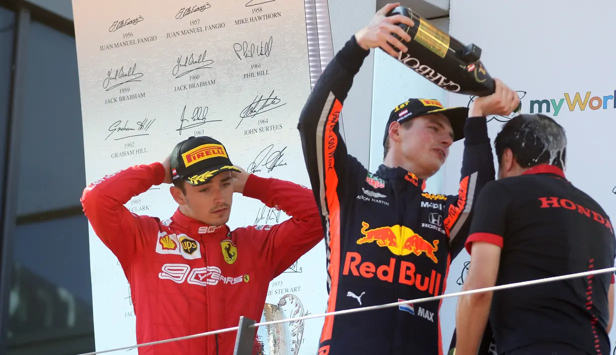 Pebalap Red Bull, Max Verstappen (tengah) menuangkan sampanye ke anggota staf tim usai memenangkan F1 GP Austria di Red Bull Ring, Spielberg, Minggu (30/6/2019). Max Verstappen menggeser Sebastian Vettel dari peringkat ketiga klasemen F1. (AP Photo/Ronald Zak)