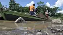 Aktivitas penambang saat bongkar muat pasir dari perahu di Sungai Klawing, Desa Toyarejo, Purbalingga, Jawa Tengah, Minggu (15/5/2022). Aktivitas penambang pasir di Sungai Klawing sudah ada sejak puluhan tahun lalu dengan menggunakan perahu dan dikerjakaan masih secara tradisional. (merdeka.com/Iqbal S Nugroho)