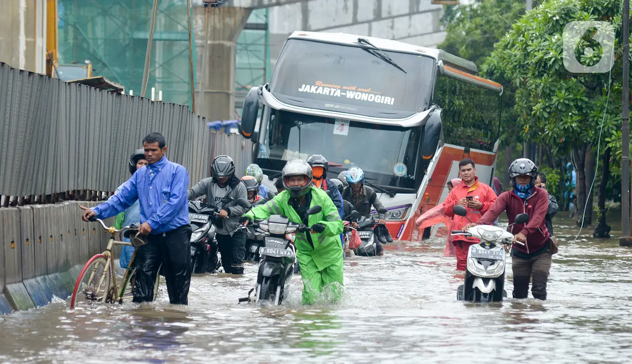 Pengendara mendorong motornya melintasi banjir di Jalan Raya Bekasi, Jakarta Timur, Selasa (25/2/2020). Banjir akibat hujan yang melanda Bekasi sejak Selasa (25/2) dini hari memutus beberapa titik jalan raya di wilayah setempat. (merdeka.com/Imam Buhori)