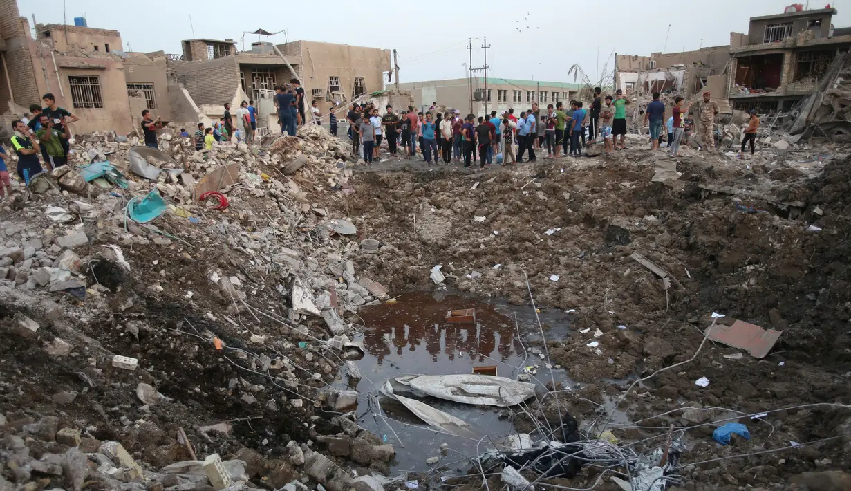Warga sipil berkumpul di lokasi ledakan di Kota Sadr di Baghdad, Irak, (7/6). Sepasang ledakan tersebut menghancurkan sebuah masjid di distrik mayoritas Syiah di Baghdad yang menewaskan dan melukai warga sipil termasuk anak-anak. (AP Photo/Karim Kadim)