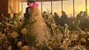 Di tengah dekorasi penuh bunga berwarna putih, Chen dan sang istri berdiri berdampingan. [Foto: twitter/Haj_992]